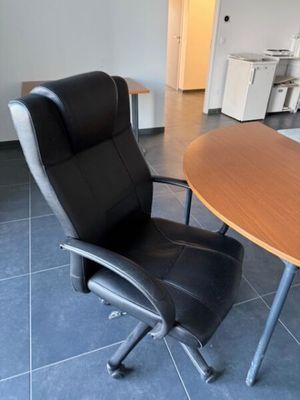 une chaise de bureau noire placée devant une table en bois