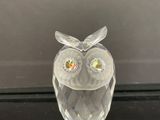 une figurine de chouette en verre posée sur une table