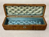 a small wooden box with a blue velvet lining