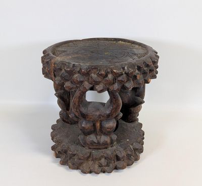 une table en bois ornée de sculptures sur un plateau blanc