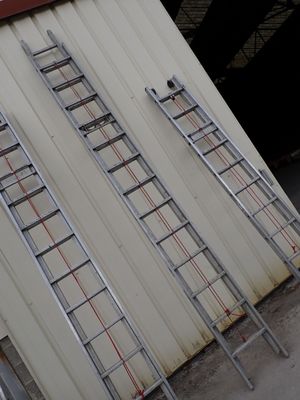 two ladders that are leaning up against a building