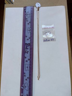 a picture of a ruler and a necklace in a box