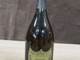une vieille bouteille de champagne posée sur une table en bois, sur fond marron