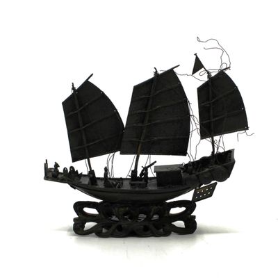 une maquette noire représentant un bateau pirate posée sur une surface blanche