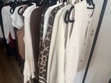 a rack of clothes hanging on a clothes rack in a room