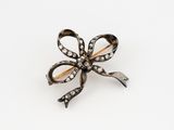 une image représentant une broche en forme de nœud en diamant sur fond blanc