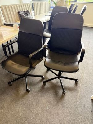 des chaises et une table dans une pièce dotée d'une grande fenêtre