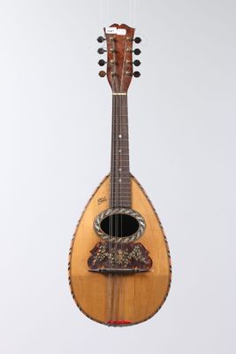 a guitar hanging from a string on a white wall