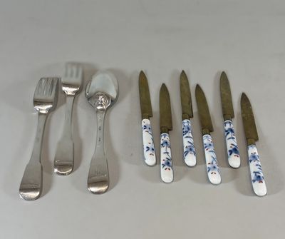 cinq fourchettes, un couteau, une cuillère et un repose-cuillère posés sur une table