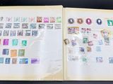 an open book with stamps on it sitting on a table