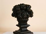 a vase with a bunch of grapes on it on a table