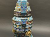 a blue and gold vase with a lion on top of it
