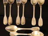 beaucoup de cuillères en argent et de cuillères à soupe sur une table