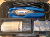 a box with a drill and other tools inside of it