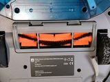 a close up of a robotic vacuum cleaner on a white surface