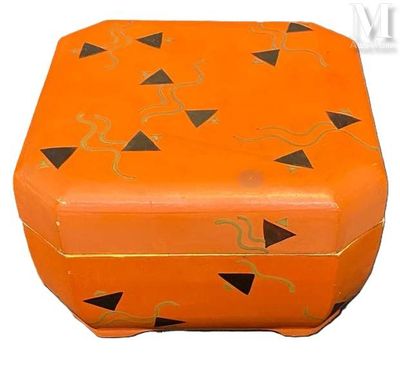 une boîte orange ornée de motifs noirs et dorés