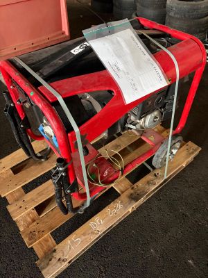 une borne d'incendie rouge posée sur une palette dans un garage