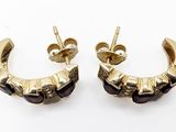 a pair of black and gold earrings on a white background