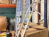 un chariot avec des cartons et une échelle dans un entrepôt