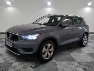 un SUV Volvo gris garé dans un garage dont le sol est à carreaux
