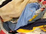 a pile of clothes in a basket on the floor