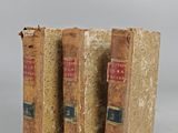 two old books sitting on top of each other on a table