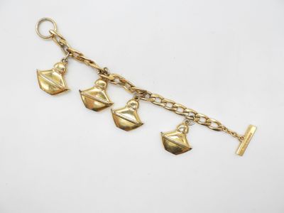 un gros plan sur un bracelet en or orné de cinq breloques