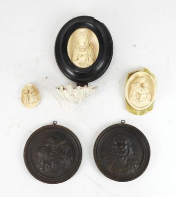 un ensemble de trois médaillons sculptés en ivoire et noir sur un fond blanc