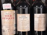 several bottles of red wine are lined up on a shelf