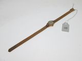 gros plan d'une montre sur une surface blanche avec une étiquette de prix