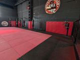 the inside of a gym with a red and black floor
