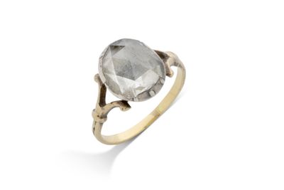 un gros plan d'une bague en or sertie d'un diamant gris facetté