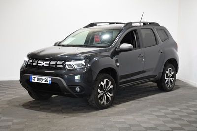 Une Dacia grise est garée dans une pièce au sol carrelé