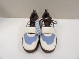pair of white and blue sneakers with brown laces sitting on a white surface