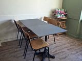 a table and chairs in a room with wood floors