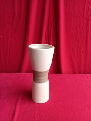 a white vase with a brown band around it