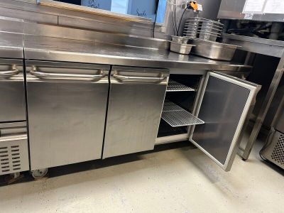 une grande cuisine en inox équipée d'un évier et d'un réfrigérateur