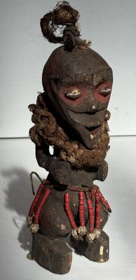 une vieille statue en bois représentant un homme barbu coiffé d'un chapeau