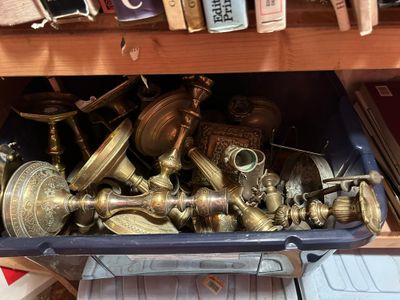 un bac bleu rempli d'objets en laiton posé sur une étagère