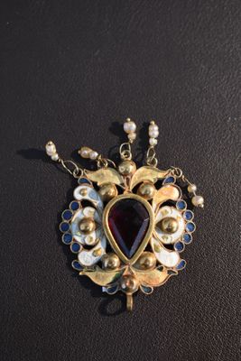 un gros plan sur un collier orné de perles et d'un pendentif en forme de cœur