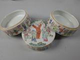 three chinese porcelain bowls with lids on a gray surface