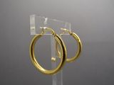 a pair of gold hoop earrings on a clear display stand