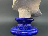 a blue vase with a white marble head on it