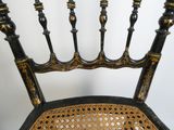 une chaise noire et dorée, avec une assise et un dossier noirs