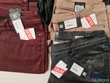 three pairs of red, brown, and black pants on a table