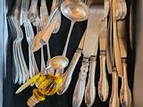 beaucoup de couverts dans une boîte posée sur la table