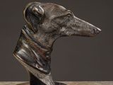 statue of a greyhound dog with a collar on a marble surface