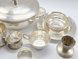 an assortment of silver plated items including cups, saucers, and saucers
