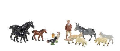 several figurines of horses and a man with a dog in a field