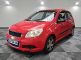 La Chevrolet Aveo rouge est garée sur un sol à damier.